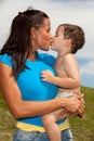 Pretty young woman kissing a cute boy Royalty Free Stock Photo