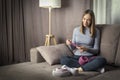 Pretty young woman knitting at home.