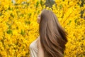 Pretty young woman with long blowing hair on floral background outdoor Royalty Free Stock Photo