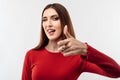 Pretty Young woman with long chestnut hair looking at the camera and pointing her finger at you. Human emotions concept Royalty Free Stock Photo