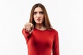 Pretty Young woman with long chestnut hair looking at the camera and pointing her finger at you. Human emotions concept Royalty Free Stock Photo