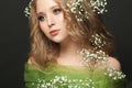 Pretty young woman with long healthy curly hair and white flowers on black background, beautiful face close up Royalty Free Stock Photo