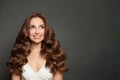 Pretty young woman with long wavy brown hair smiling and looking up on black background Royalty Free Stock Photo