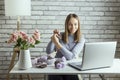 Pretty young woman make artificial roses of paper and showing online. Royalty Free Stock Photo