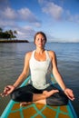 Pretty young woman in meditation on the water at Ala Moana state