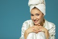 Pretty young woman, morning procedures. Charming girl with towel on her head wearing bathrobe looking at camera like at mirror, Royalty Free Stock Photo
