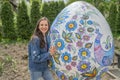 Pretty young woman near big Pysanka. Ukrainian Easter egg, exhibit of museum Pysanky, Ivano-