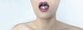 A young woman with neat make-up holds a blue pill with her lips. Sexy lips painted with red lipstick. Prevention and treatment of