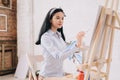 Pretty Young Woman Painting at Easel Royalty Free Stock Photo