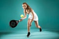 Pretty young woman playing padel indoor over green-blue background.