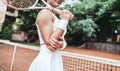 Pretty, young woman playing tennis in a city park on a lovely summer day Royalty Free Stock Photo