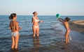 Pretty young woman plays ball with her daughters