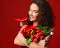 Pretty young woman posing with fresh red vegetables radish chili pepper green leaves lettuce parsley fork and spoon Royalty Free Stock Photo