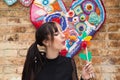 Pretty young woman in punk style holds a colourful windmill in her hand. She is blowing it to make it spin. Summer, air Royalty Free Stock Photo