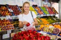 Girl customer buying red pepper at grocery shop Royalty Free Stock Photo