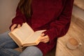 pretty young woman reading a book and drinking coffee happily, sitting on some stairs Royalty Free Stock Photo