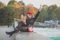 Pretty young woman in red beret holding craft paper bag with fresh french baguette. Royalty Free Stock Photo