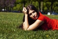 pretty young woman in red dress smiling cheerful in green park on summer sunny day, lifestyle people concept Royalty Free Stock Photo