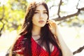 Pretty young woman in red dress smiling cheerful in green park at tree on summer sunny day, lifestyle people concept Royalty Free Stock Photo