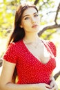 Pretty young woman in red dress smiling cheerful in green park at tree on summer sunny day, lifestyle people concept Royalty Free Stock Photo