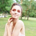 Pretty young woman with bright make up. Outdoor green portrait