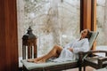 Pretty young woman relaxing by the indoor swimming pool at winter Royalty Free Stock Photo