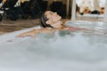 Young woman relaxing in the indoor swimming pool Royalty Free Stock Photo