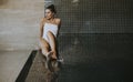 Young woman relaxing on the poolside of indoor swimming pool Royalty Free Stock Photo