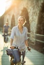 Pretty, young woman riding a bicycle in a city Royalty Free Stock Photo