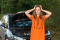 Pretty, young woman by the roadside after her car has broken down - Image Royalty Free Stock Photo