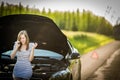 Pretty, young woman by the roadside after her car has broken down Royalty Free Stock Photo