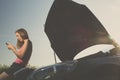 Pretty, young woman by the roadside after her car has broken down Royalty Free Stock Photo