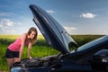 Pretty, young woman by the roadside after her car has broken down Royalty Free Stock Photo