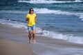 Pretty young woman runs along the beach Royalty Free Stock Photo