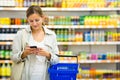 Pretty, young woman with a shopping basket buying groceries Royalty Free Stock Photo