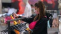 Pretty young woman shopping in clothes store