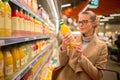 Pretty, young woman shopping for her favorite fruit juice Royalty Free Stock Photo