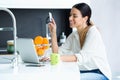 Pretty young woman shopping online with credit card while staying in the kitchen at home Royalty Free Stock Photo