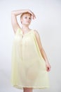 Pretty young woman with short hair and chubby body wearing transparent nightgown and posing on white studio background alone. beau Royalty Free Stock Photo