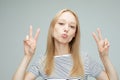 pretty young woman showing the peace sign on grey color background Royalty Free Stock Photo