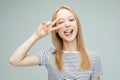 pretty young woman showing the peace sign on grey color background Royalty Free Stock Photo