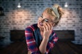 Pretty young woman sits on the bed in stylish bedroom. Russian blonde girl Royalty Free Stock Photo