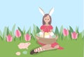 Pretty young woman sitting with basket of painted eggs and rabbit in green grass. Festive spring illustration can be used for Royalty Free Stock Photo