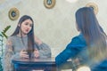 Pretty young woman sitting in a cafe. A nice and warm shot of a Caucasian girl in casual clothing through a window glass Royalty Free Stock Photo