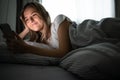 Pretty, young woman sleeping in her bed with her cell phone close to her Royalty Free Stock Photo