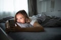 Pretty, young woman sleeping in her bed with her cell phone close to her Royalty Free Stock Photo