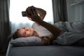 Pretty, young woman sleeping in her bed with her cell phone Royalty Free Stock Photo