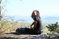Papuan girl sitting on rock in Czech Switzerland