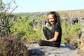 Papuan girl sitting on rock in Czech Switzerland