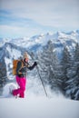 Pretty, young woman snowshoeing in high mountains